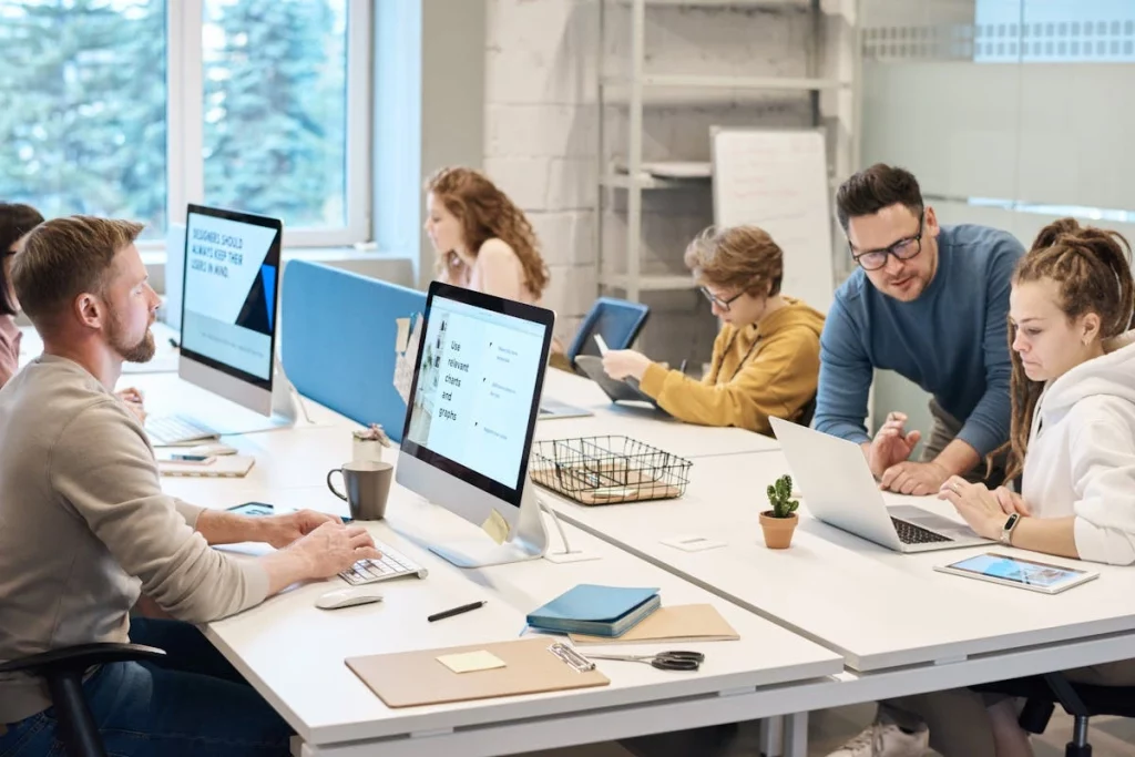 Imagem de pessoas trabalhando em escritório, com cadeira e mesa